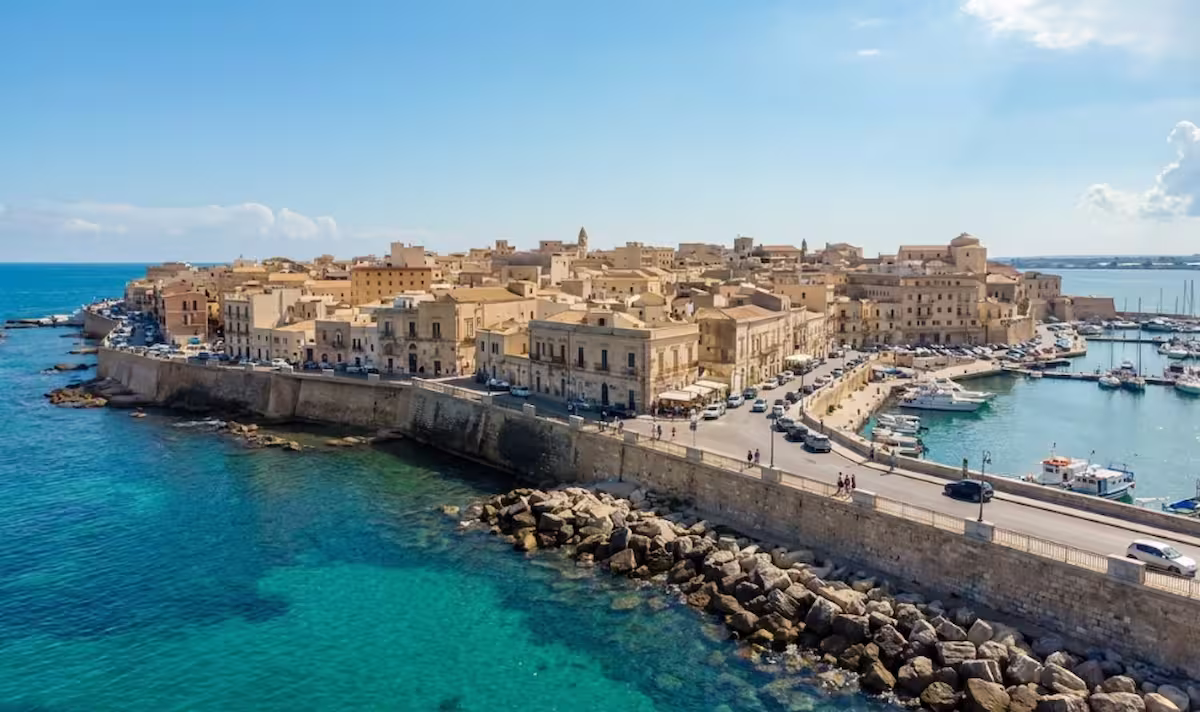Qué ver en Siracusa y la Isla de Ortigia en un día: 10 cosas que ver y hacer en Sicilia 2 Vista panorámica de la Isla de Ortigia en Siracusa durante el atardecer con el mar Mediterráneo.